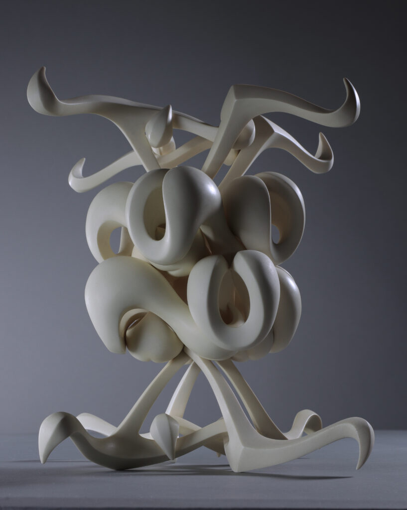 A tall spiral sculpture by local sculptor Isaac Bower sits against a grey background.