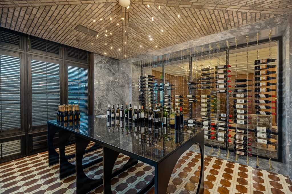 Marble wall with wine rack, marble floor and other stone features by Armina Stone at the Fawn & Fable restaurant and Nemacolin.