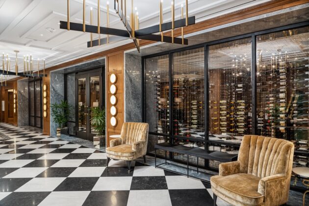 Marble wall with wine rack, marble floor and other stone features by Armina Stone at the Fawn & Fable restaurant and Nemacolin.