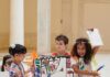 Community Summer Programs for Kids in Pittsburgh Three kids in a summer program show off an art poster inside the Carnegie museum.