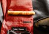 A Pittsburgh Father’s Day Gift Guide On top of a red tie and beside a pair of men's black shoes sits a black bowtie, cigar, and watch,