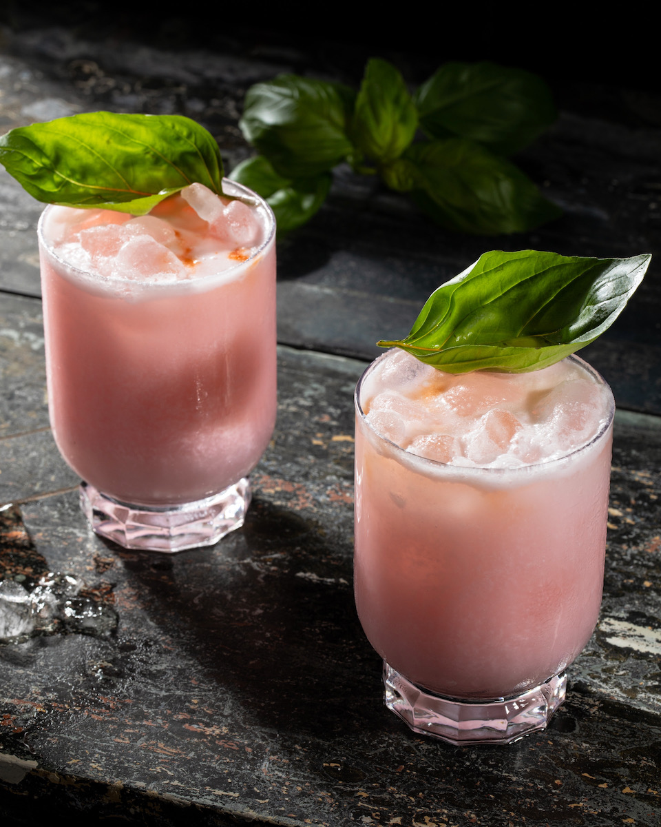 Two pink cocktails on a black background, by Ineffable Ca Phe's team