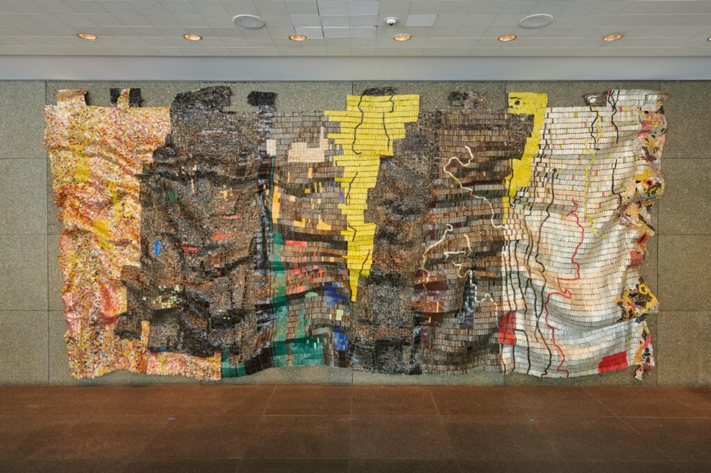 An artwork textured and in various colors hangs on the wall at Carnegie Art Museum in Pittsburgh