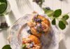 Must-Try Seafood in Pittsburgh A white plate holds two seafood stuffed buns from the Pittsburgh restaurant Lilith surrounded by plant leaves.