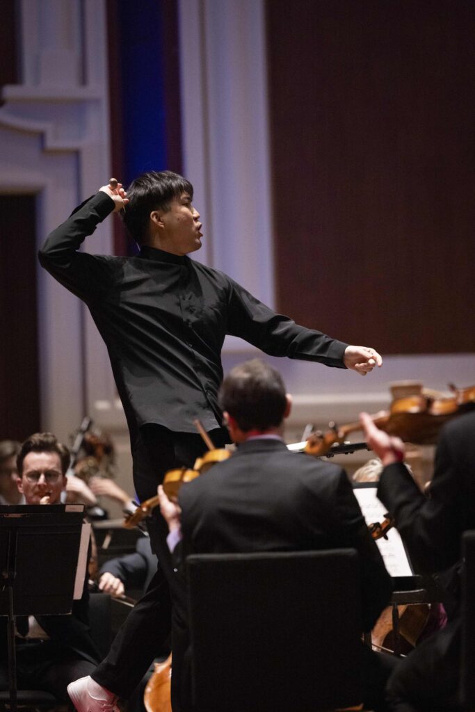 A man in black clothing directs the Pittsburgh orchestra in a musical celebration.