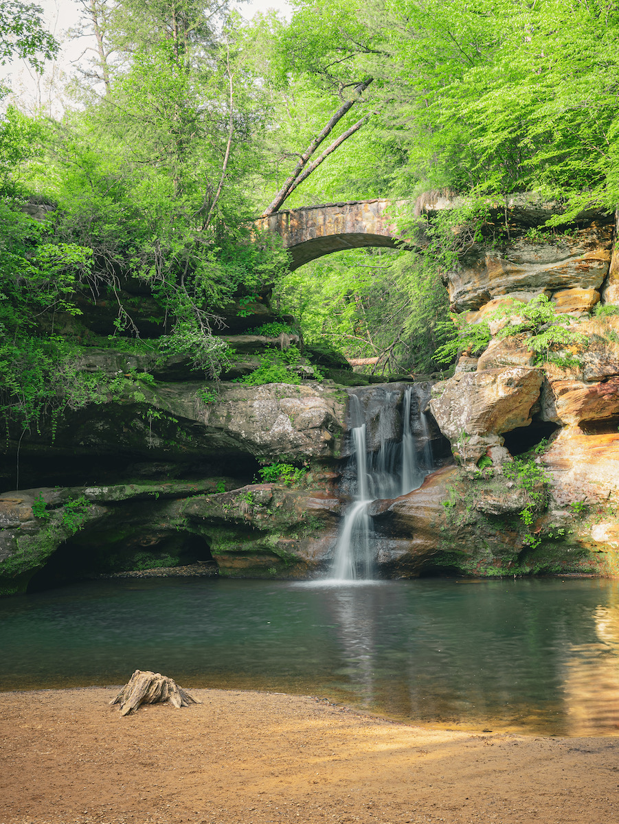 A waterfall in a sunny, green glen