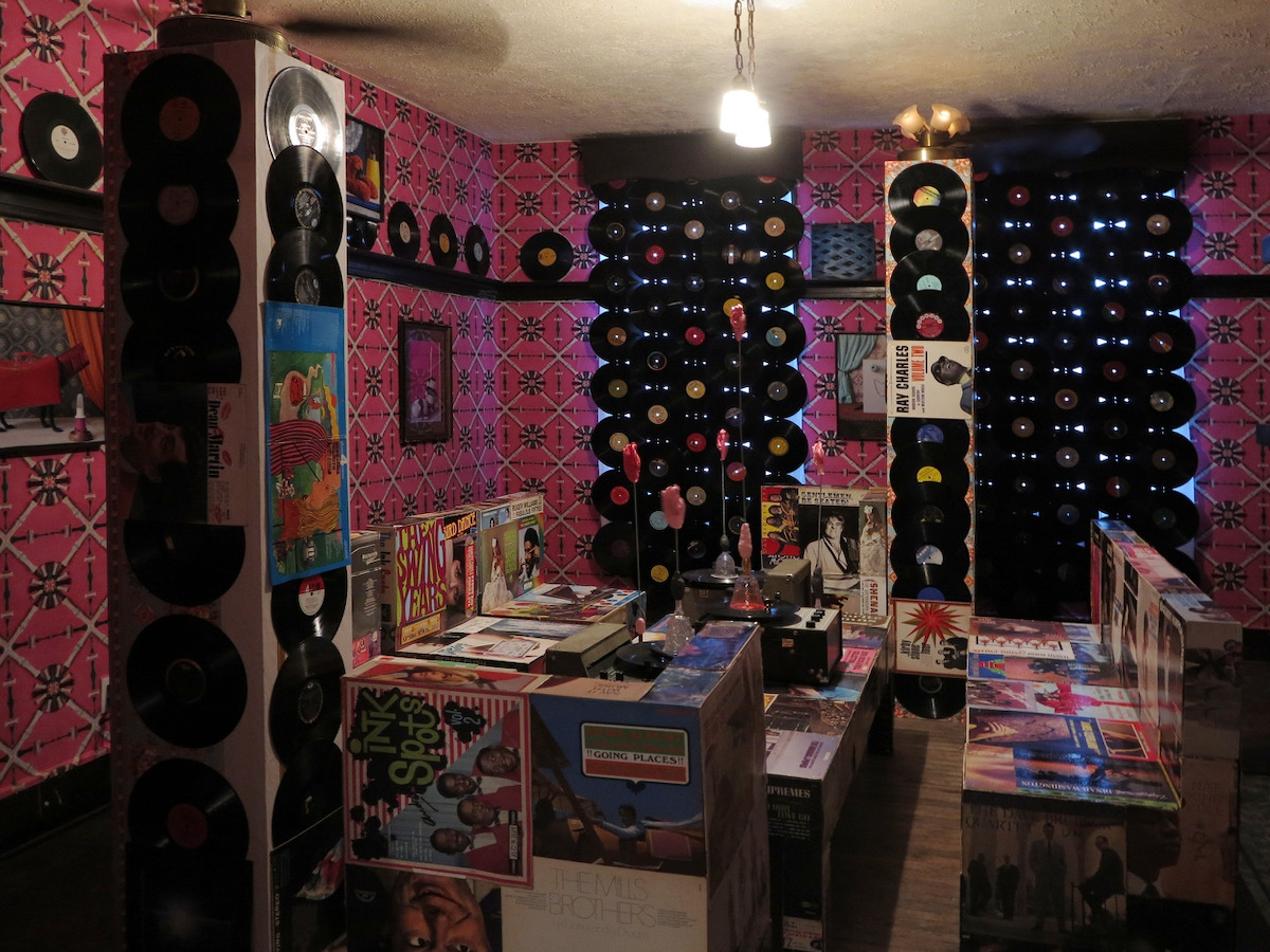 The interior of one of the Troy Hill Art Houses with vinyl records over the windows and red walls