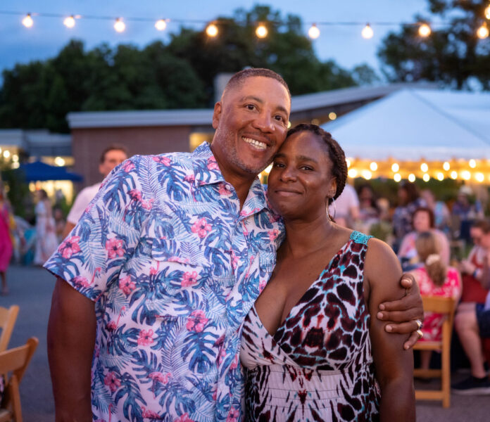 Night in the Tropics TABLE Magazine Two people pose together in tropical print clothes at a Night in the Tropics at the aviary.