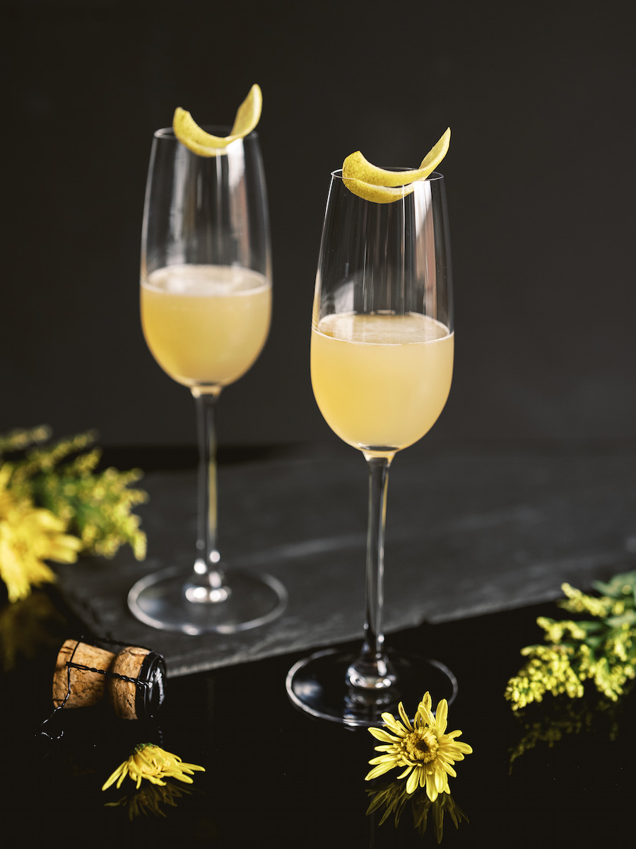 A pale yellow cocktail in a champagne flute glass