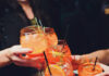 A Night Out at Spritzery, Pittsburgh’s Hottest Pop-Up Bar People cheers several orange aperol spritzes together