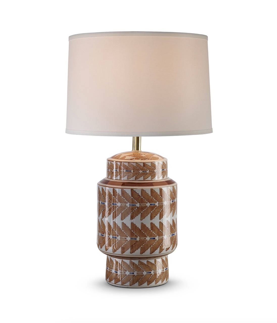 A table lamp with indigenous designs on the base sits against a white backdrop.