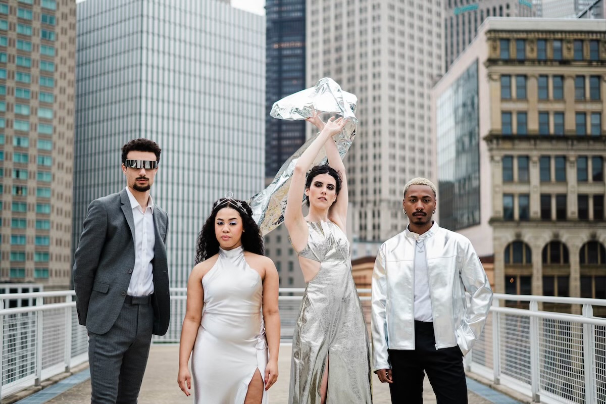 Four people on the David L. Lawrence rooftop dressed In stylish clothing for Riverlife's Party at the Pier: Galactic.