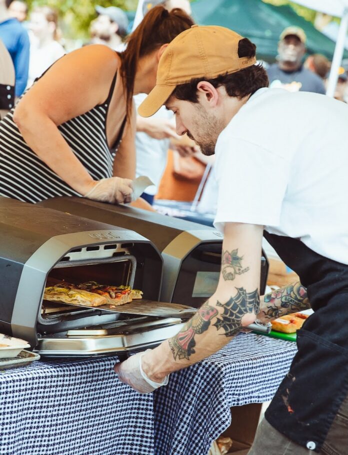 A man pulls a pizza out of the oven at Pittsburgh VegFest.