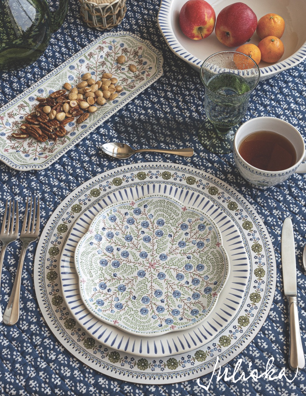 A white and blue patterned plate sits in the middle of a blue table cloth.