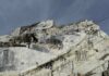 From Quarry to Kitchen: The Art of Curating at Armina Stone A man standing with his arms stretched in a stone quarry.