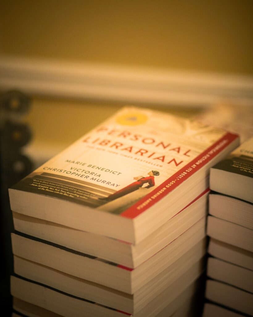 A stack of The Personal Librarian books sits on a table.