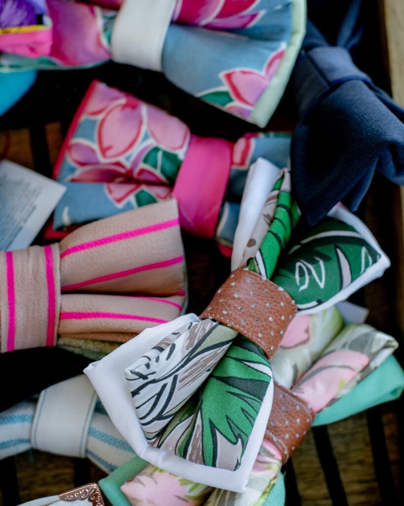 Various patterened hair bows made sit in a box together.