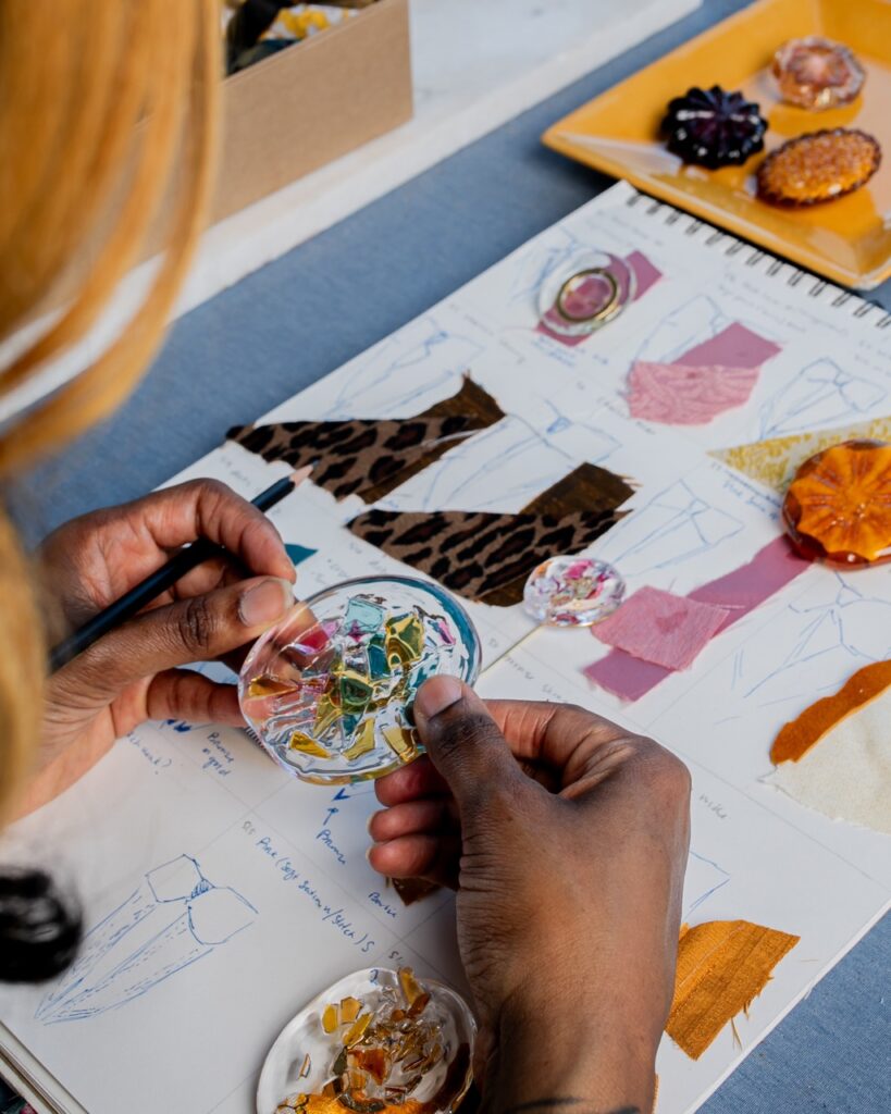 Nisha Blackwell looks over a piece of round, glass like textile.