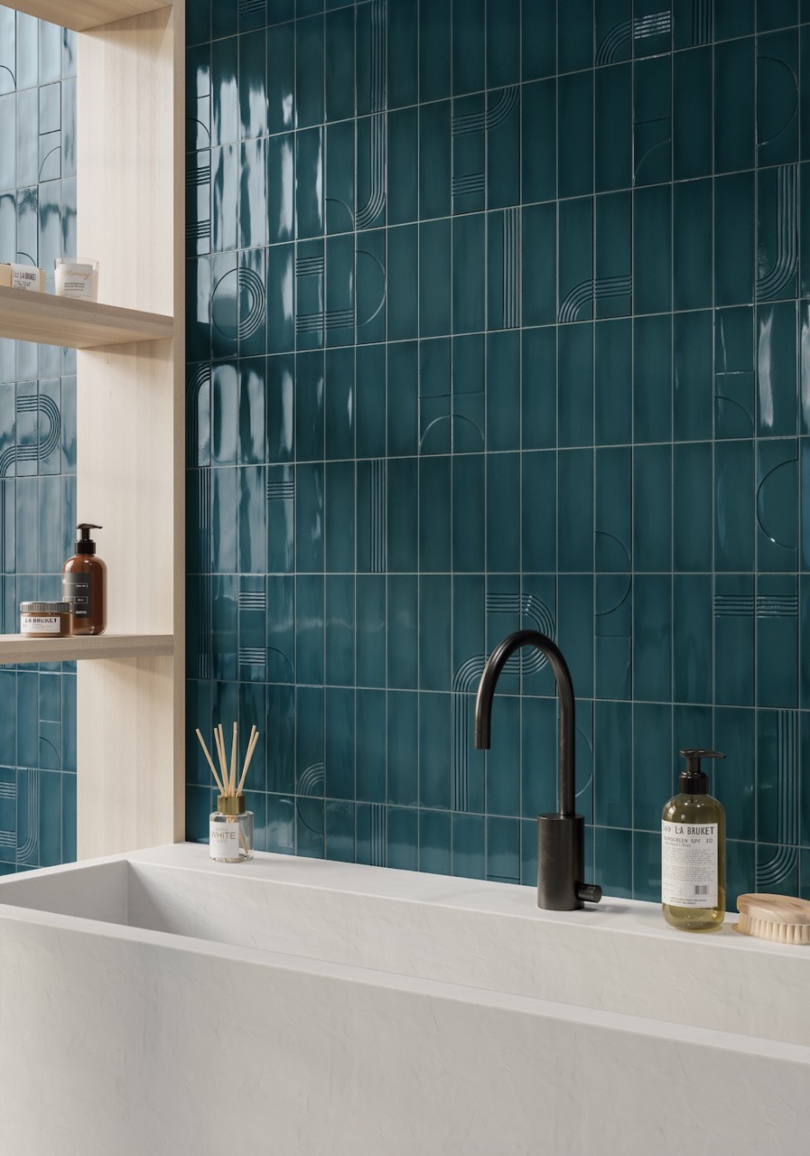 A nostalgia colored tile bathroom in a dark emerald color wraps around a modern bathtub in white. 