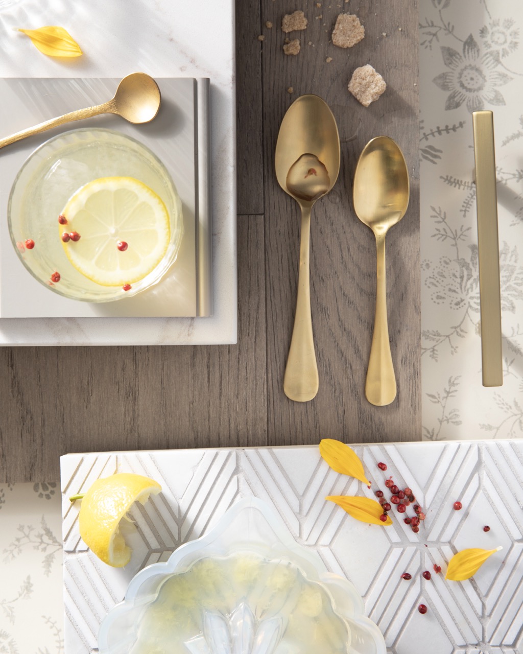 Pieces of gold silverware sits on a wood table with nostalgia design placemats below them.