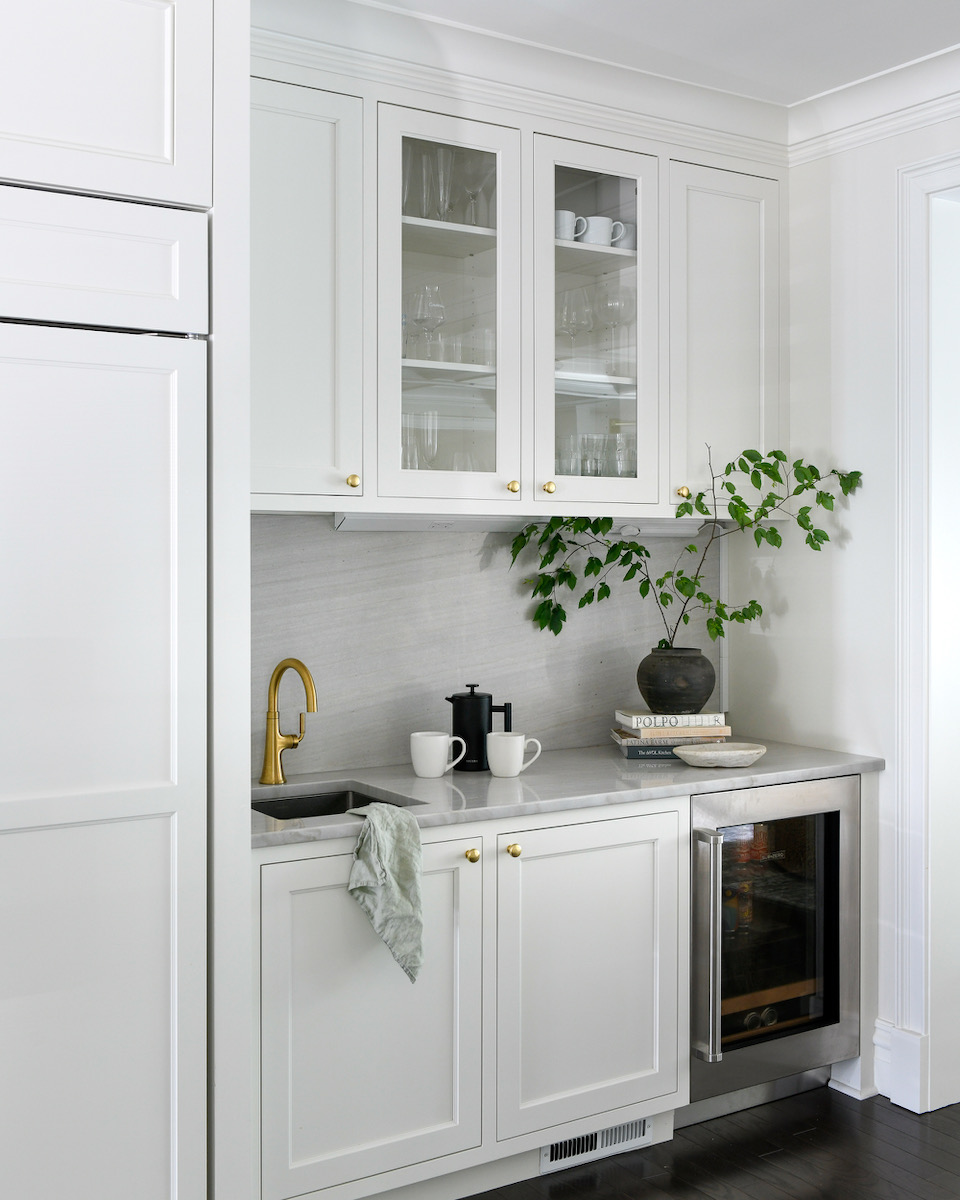 A white cabinet with a plant seated on top of it 