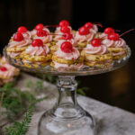 A glass plate of cherry pistachio sandwich cookies