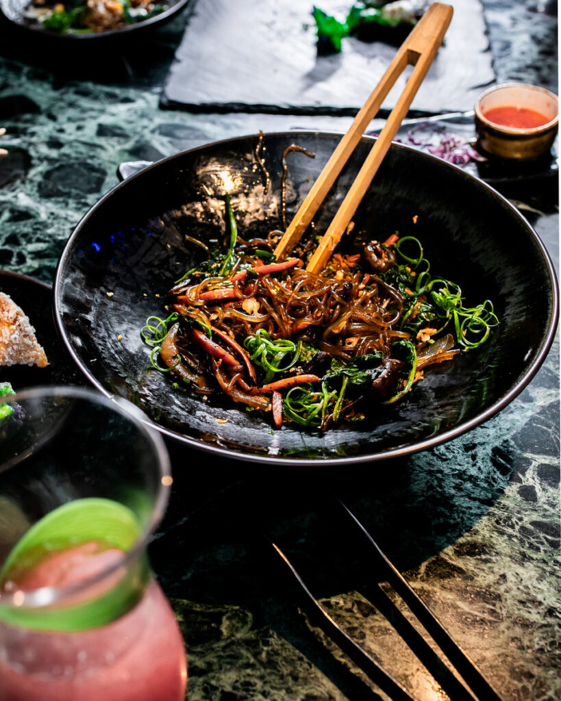 A bowl of food with chopsticks on a table