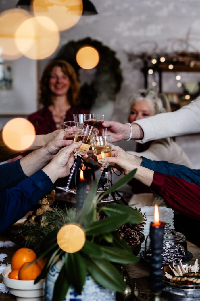 The Dessert Table {Winter TABLE} A group of people cheers champagne glasses over a table.