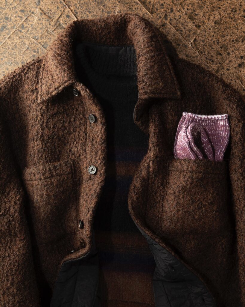 A brown wool jacket with a purple pocket scarf.