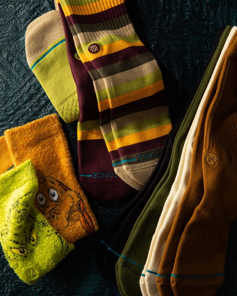 Green, orange, and brown socks with Grinch and Max socks nearby.