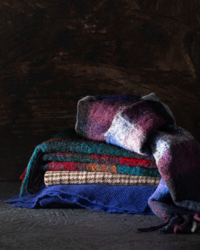 A stack of various color and pattern scarves.