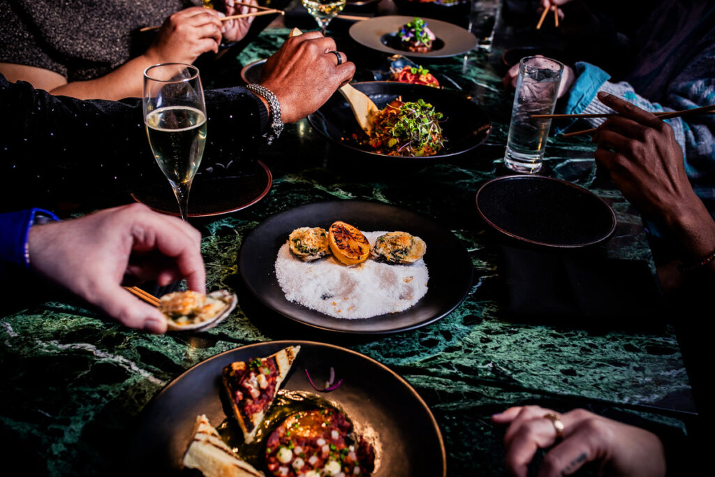 A group of people sitting around a table eating food.