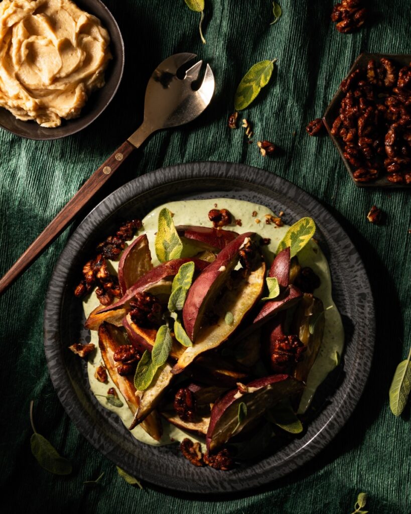 A plate of roasted Japanese sweet potatoes wih a tahini sauce on top.