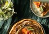 Root Vegetable Galette A round root vegetable galette with vegetables spiraled on top sits on a green plate with a slice taken out of it.
