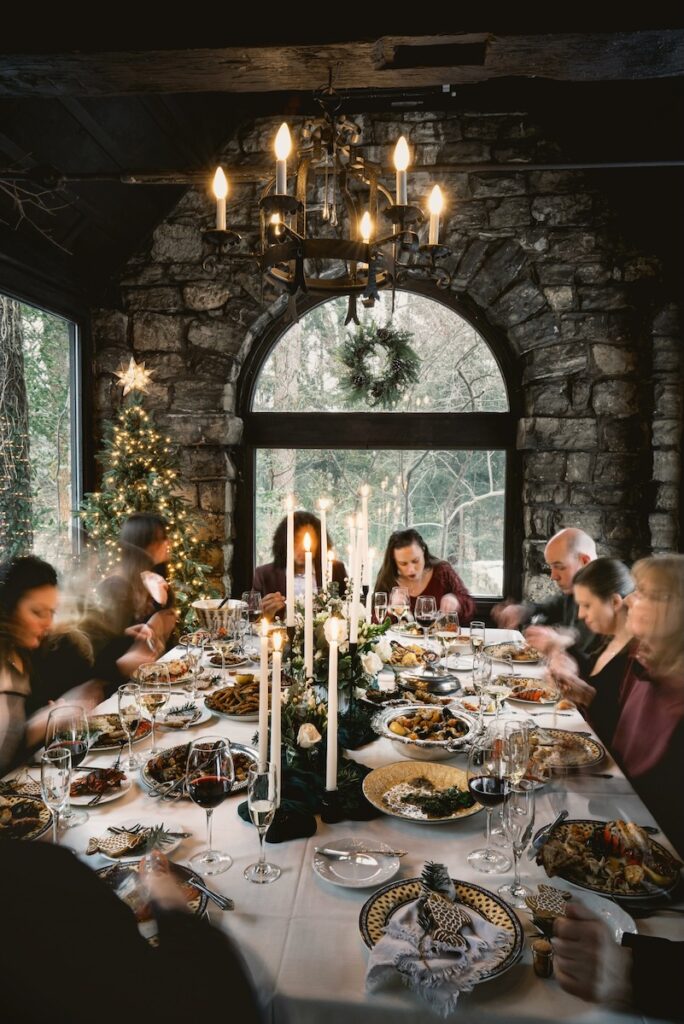 A group of people eat a seven fishes feast prepared by two Pittsburgh chefs in a rustic setting. 