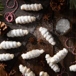 Small white cookies, lady locks, on a dark brown background