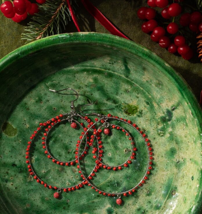 Women's Holiday Gift Guide TABLE Magazine 11 A set of round red hoop earrings sits on a green plate.