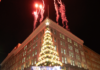 Highmark Light Up Night Pittsburgh Releases 2025 Schedule The Pittsburgh Highmark building lit up with a Christmas Tree on the corner, fireworks in the sky, and a stage on the ground.