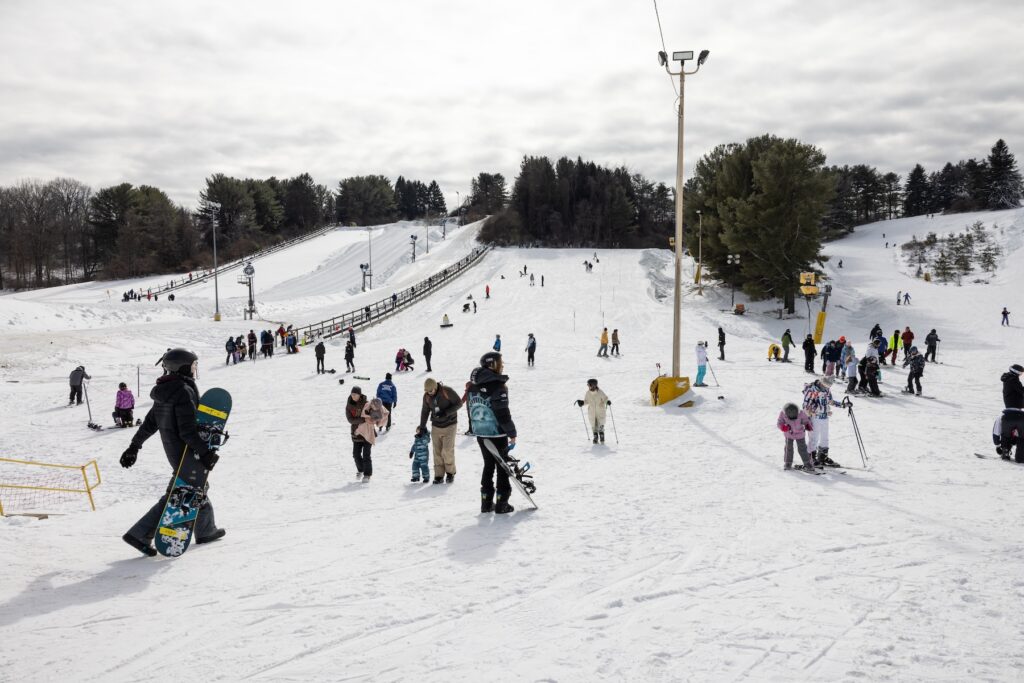 A variety of different people on a snowy ski slope.