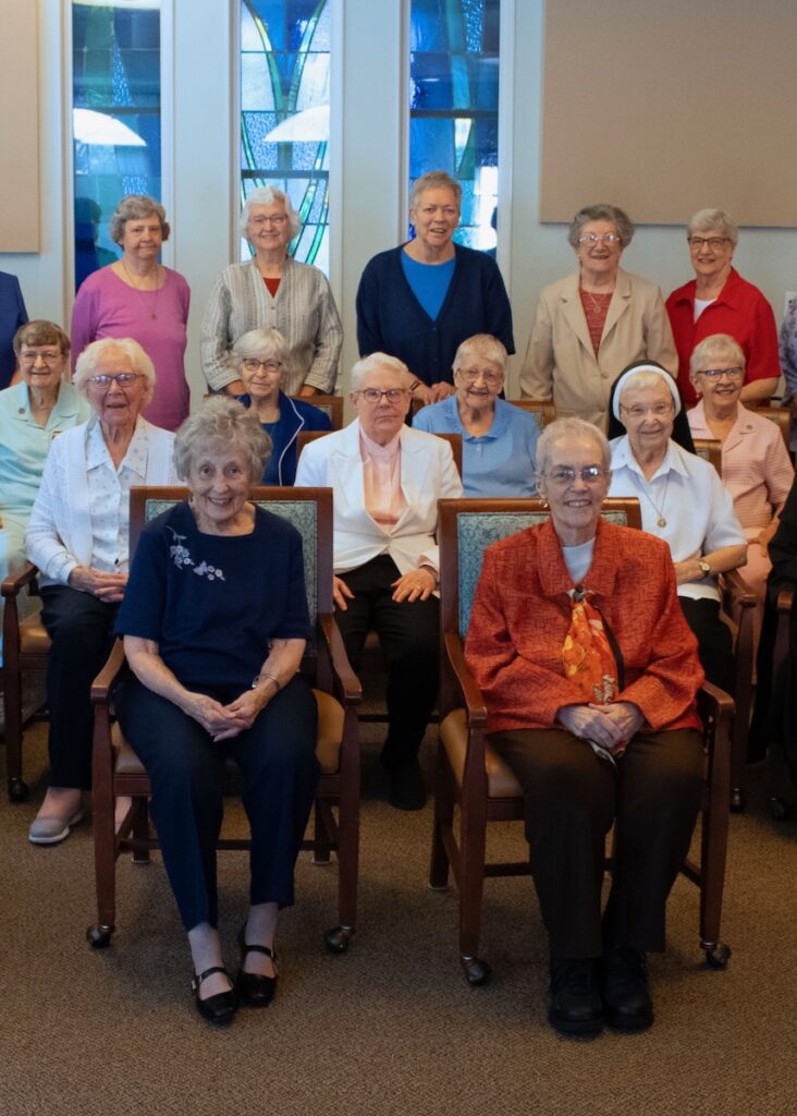 A group of older women sitting in chairs.
