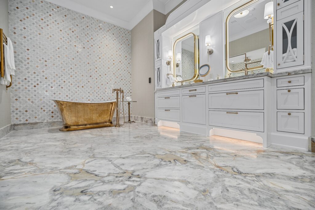 A luxurious white bathroom with marble flooring by Amina Stone, a double vanity, and a copper tub.