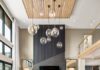 Beyond the Countertop, The Endless Possibilities of Armina Stone A grey and tan living space with floor to ceiling windows and a floor to ceiling dark grey stone fireplace surround by Armina Stone.