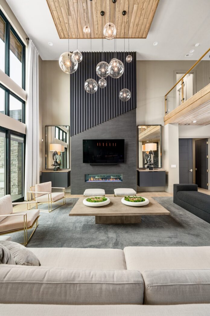 Beyond the Countertop, The Endless Possibilities of Armina Stone A grey and tan living space with floor to ceiling windows and a floor to ceiling dark grey stone fireplace surround by Armina Stone.