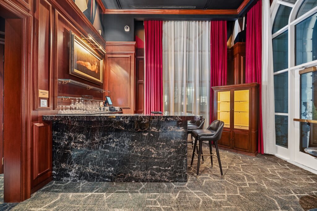 In a red room is a dark stone countertop for a home bar.