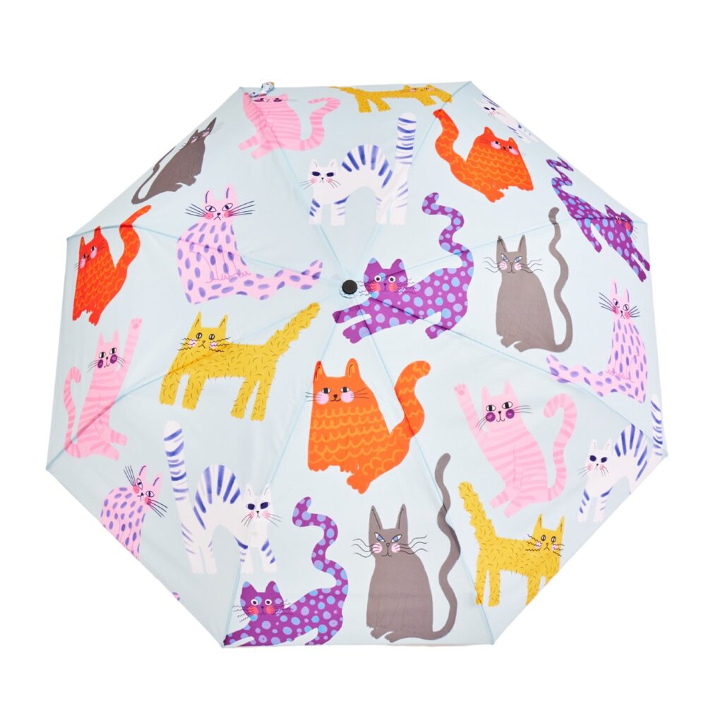 A blue umbrella with cartoon cats all over it.