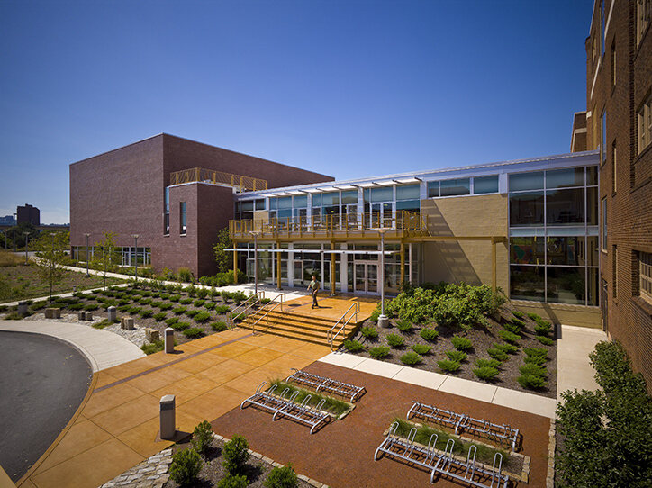 The outside of the Sarah Heinz House building in brick with large walls of windows and a garden outside the entrance.