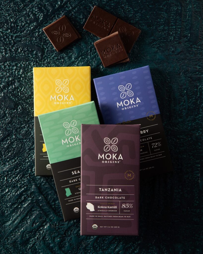 Four chocolate bars sitting on a green surface.