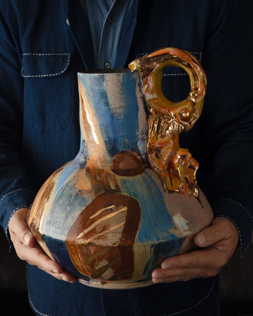 A blue and orange pottery vase.