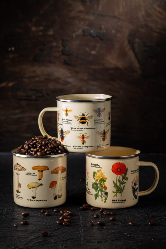 Three mugs with mushrooms, bees, and plants on them.