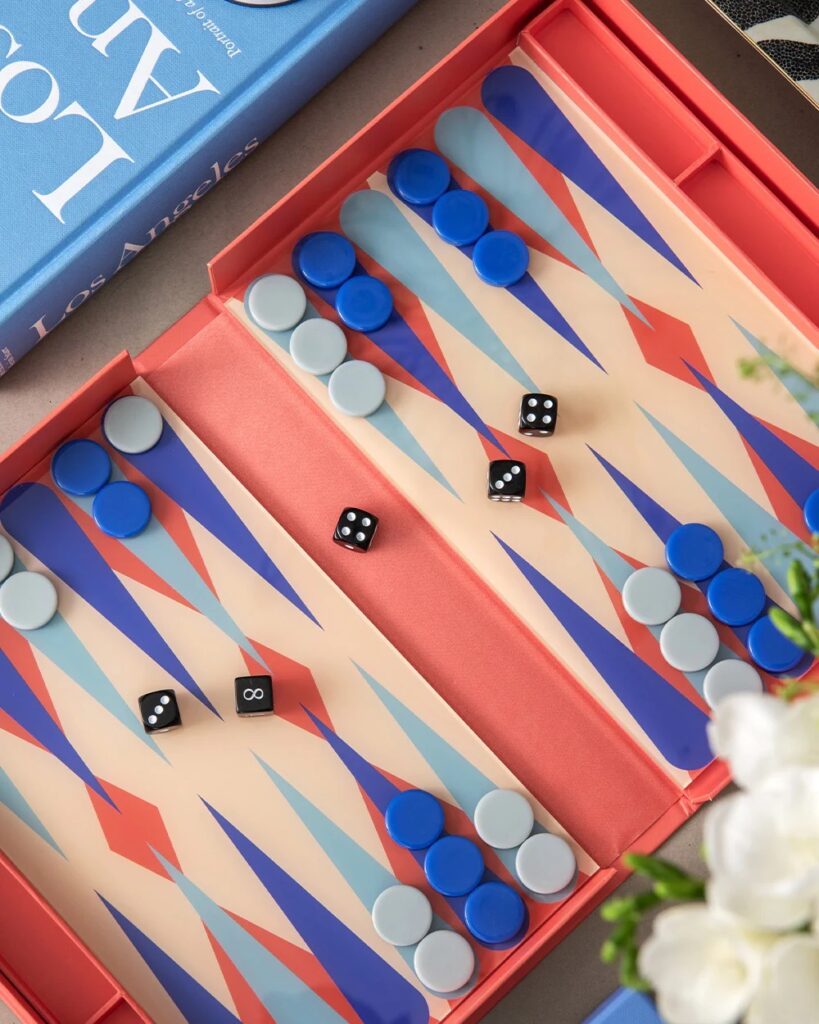 A board game in blue and red colors with black dice on the board.